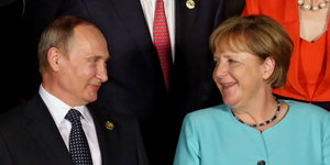 Putin und Merkel gucken sich an