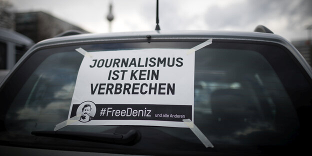 Eine Autoscheibe mit einem "Free Deniz"-Plakat