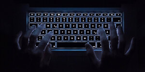 Hände auf einer beleuchteten Tastatur