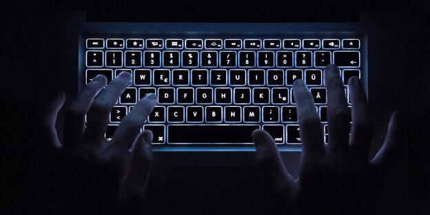Hände auf einer beleuchteten Tastatur