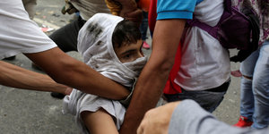 Ein Verletzter Demonstrant wird von Helfern weggetragen