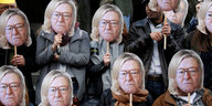 Aktivist_innen halten Masken vor ihre Gesichter, auf denen Jean-Marie Le Pens Gesicht mit den Haaren seiner Tochter zu sehen ist