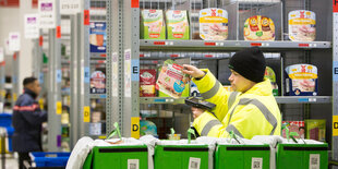 Ein Mitarbeiter von AmazonFresh scannt im Depot in Berlin Produkte