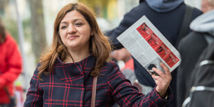 Die Spitzenkandidatin der Linken Özlem Alev Demirel hält ein Wahlkampfprogramm hoch