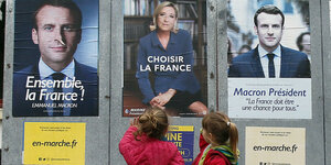 Kleine Mädchen stehen vor Wahlplakaten