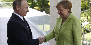 Putin schüttelt Merkel die Hand