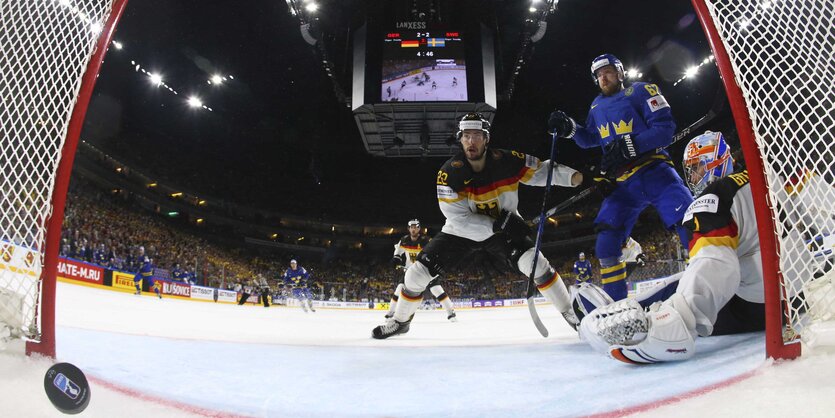 Eishockeyspieler und ein Puck im Tor