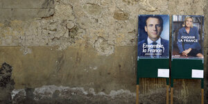 Zwei Wahlplakate vor einer Wand mit altem Putz