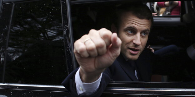Emmanuel Macron streckt seine Faust aus dem Auto