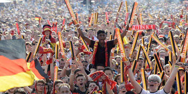 Hunderte Menschen jubeln mit Deutschlandflaggen