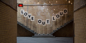 An einer Wand steht "Love Out Loud"