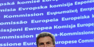 Günther Oettinger vor einer Leinwand, auf der "Europäische Kommission" steht
