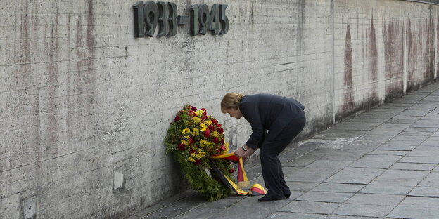 Angela Merkel legt einen Kranz unter die Jahreszahlen 1933-1945 der Gedenkstätte KZ Dachau