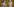 Figuren mit langen Nasen und kahlen Köpfen bewegen sich in blaues Licht getaucht auf einer Bühne