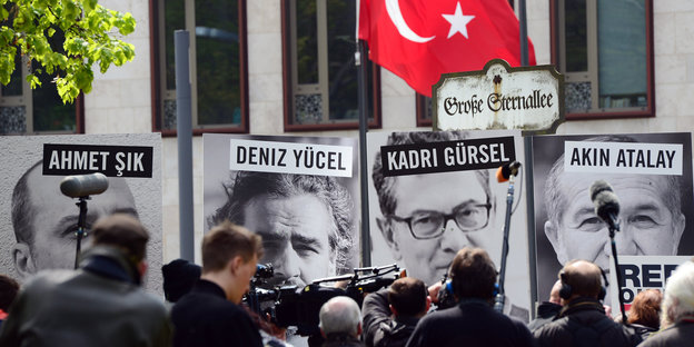 Menschen, Plakate mit Gesichtern von Journalisten und die türkische Flagge