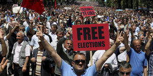 Ganz viele Demonstranten, im Vordergrund ein Schild mit der Aufschrift „Free Elections“