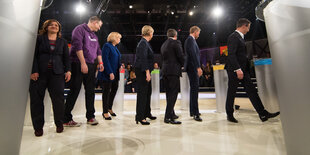 Sieben Frauen und Männer in einem Fernsehstudio