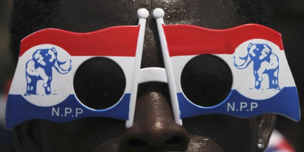 Ein Gesicht hinter einer Wahlkampf-Sonnenbrille