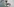 Ein Mann steht waagrecht von einem Kaugummiautomaten ab, der an der Wand befestigt ist. Er scheint also in der Luft zu schweben.