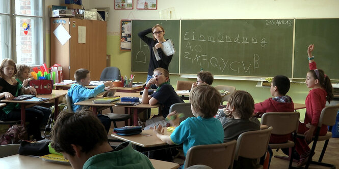 Lehrerin steht vor einer Schulklasse