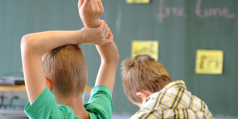 Kind meldet sich im Klassenraum