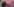 Ein Mann in schwarzer Kleidung klebt ein rotes Poster auf ein graues Zelt, darauf ist ein Herz gemalt, eine Ziffer Zwei und das Wort Block