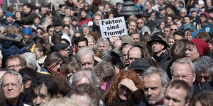 Viele Menschen und ein Schild "Fakten sind Trump"