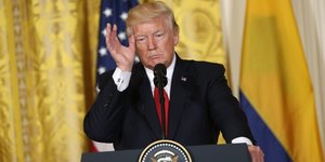 Donald Trump steht am Rednerpult, fasst sich mit der Hand an die Schläfe und sieht sehr gelangweilt aus