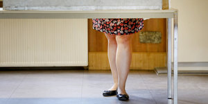 Eine Wählerin steht in der Wahlkabine. Man sieht nur ihre Beine