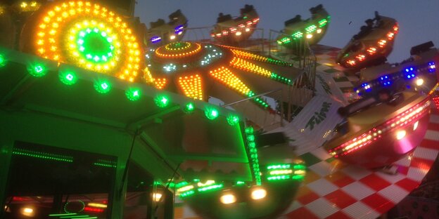 Eine Karuell in der Dämmerung, bunt beleuchtet Eine Karuell in der Dämmerung, bunt beleuchtet