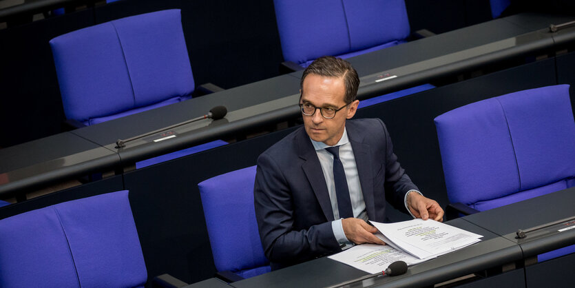 Heiko Maas sitzt allein zwischen facebook-blauen Stühlen