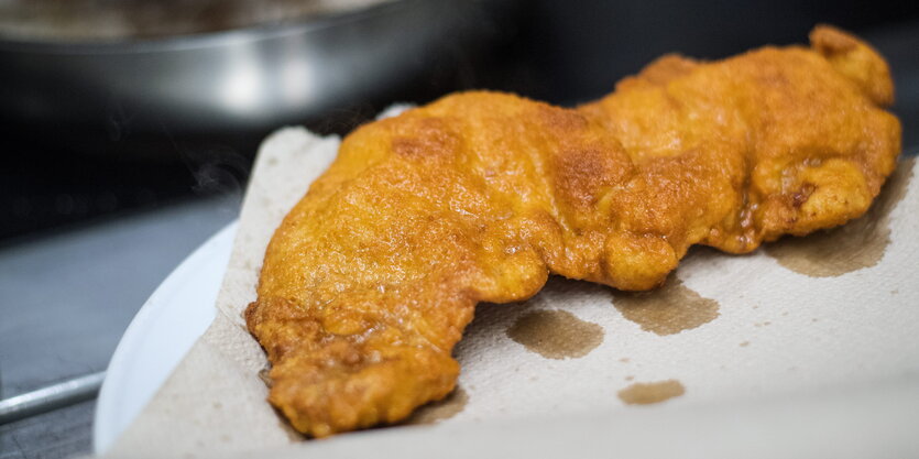 Ein Wiener Schnitzel liegt auf einem weißen Teller