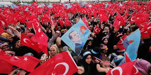 Demonstration, viele Türkeifahnen in der Luft. Ein Porträt von Erdogan wird getragen