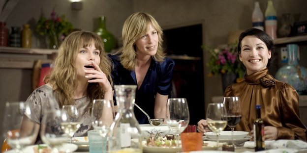 Drei Frauen sitzen am gedeckten Tisch