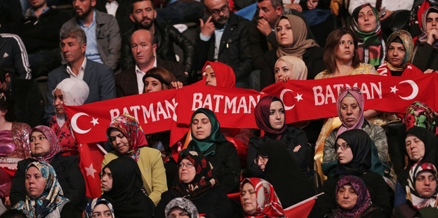 Eine Menschenmasse mit einem Banner, das den türkischen Halbmond und das Wort "Batman" trägt