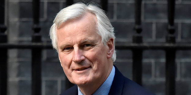 Eine Portraitaufnahme von Michel Barnier, dem Chefunterhändler der EU für den Brexit. Barnier ist grauhaarig, tägt einen dunkelblauen Anzug, ein hellblaues Hemd und eine rot-gemusterte Krawatte.
