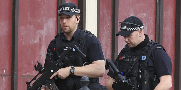 Zwei bewaffnete Polizisten patrouillern durch Manchester