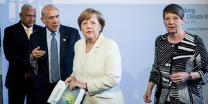 Bundeskanzlerin Angela Merkel mit zwei Männern. Hinter ihr steht Umweltministerin Barbara Hendricks