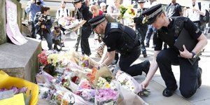 Polizisten leben Blumensträuße nieder