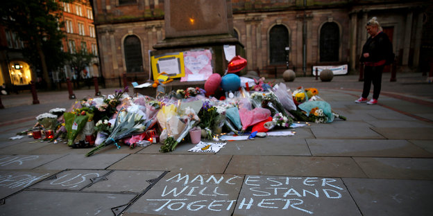 Viele Blumen liegen für die Opfer auf einem Platz in Manchester