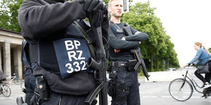Zwei schwer bewaffnete Polizisten stehen auf der Straße