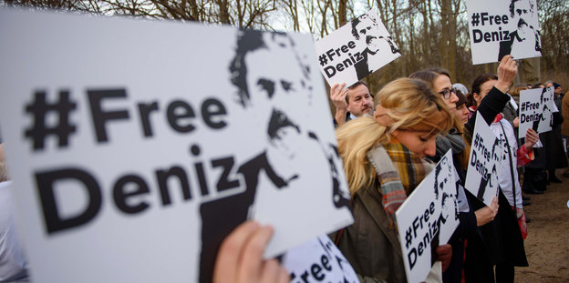 Menschen halten Schilder mit dem Aufdruck „Free Deniz“