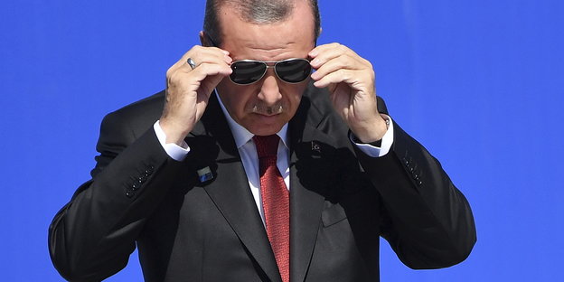 Ein Mann in schwarzem Anzug mit Sonnenbrille