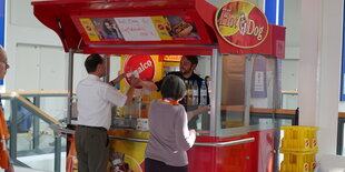 Zwei Menschen stehe an einem Currywurststand