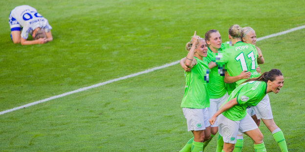 Wolfsburgs Spielerinnen umarmen sich und CS Sands Spielerin Jana Vojtekova liegt am Boden