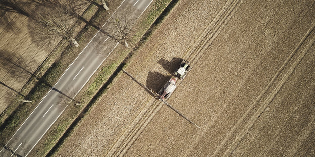 Ein Traktor fährt über ein Feld und bringt Glyphosat aus