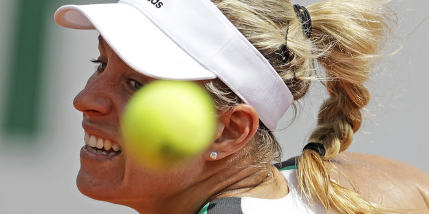 Ein gelber Tennisball verdeckt das Gesicht von Angelique Kerber