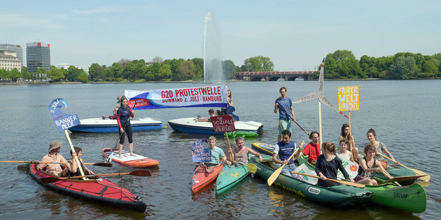 Boote auf einem See, Menschen darin halten Anti-G20-Plakate