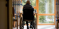 Ein alter Mann sitzt in einem Rollstuhl