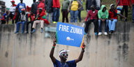 Ein Demonstrant mit Schild "Fire Zuma"